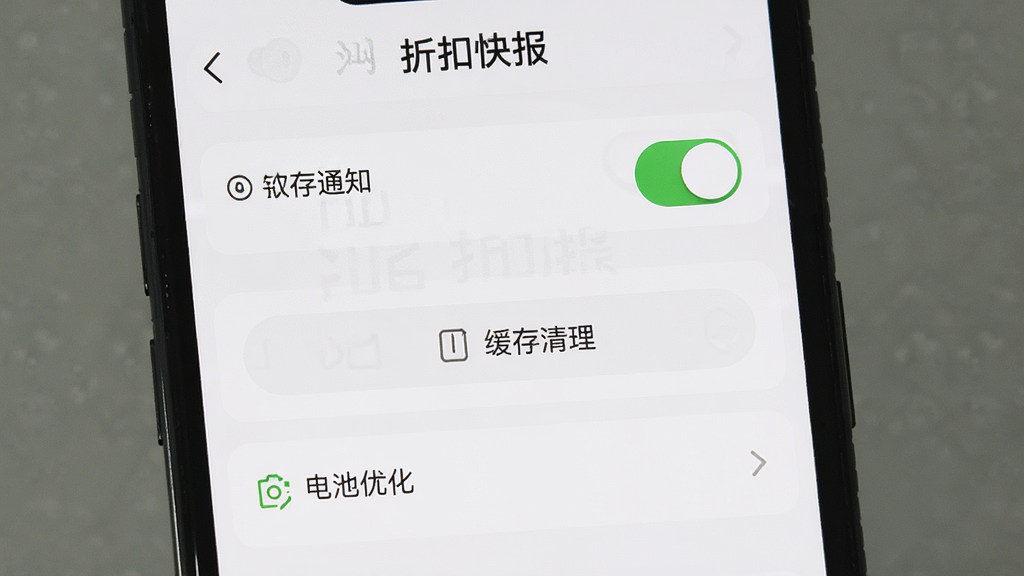 手机屏幕显示“折扣快报”的设置页面,页面上有通知开关、缓存清理按钮、电池优化选项等条目,布局清晰,文字标签明确,风格简洁现代,画质干净,无多余元素