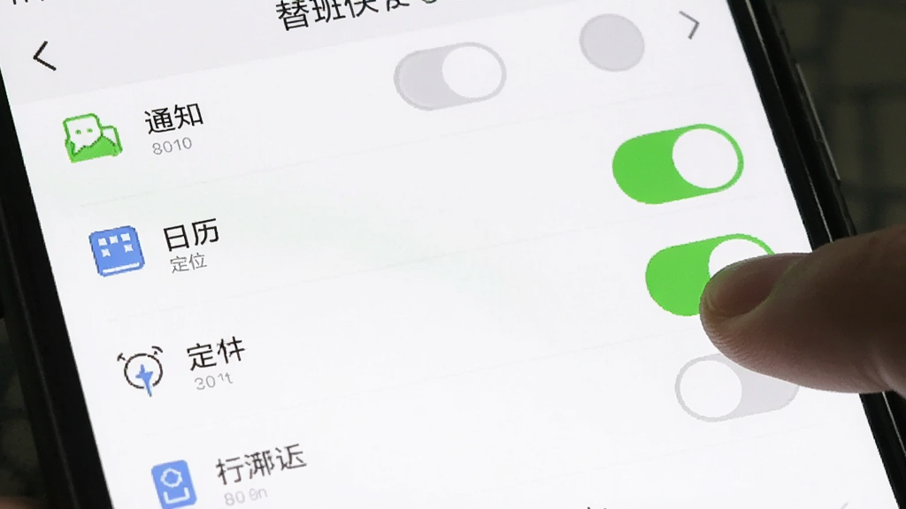 一张手机屏幕截图,画面展示替班侠APP的权限设置页面,列表中有通知、日历、定位等权限开关,旁边有手指正在点击开启通知权限,界面风格简洁,背景白色,文字清晰,画质干净,无多余元素。