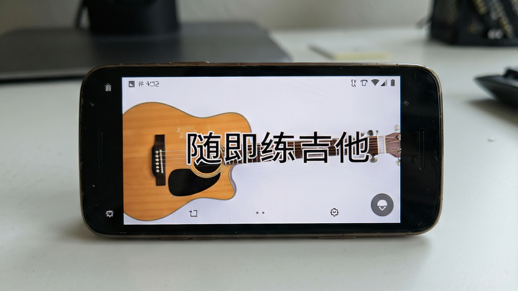 一张展示“随即练吉他”App在旧款安卓手机上流畅运行的场景图,手机屏幕显示App主界面,画面强调“随即练吉他”字样,背景是简洁的桌面,风格写实,细节清晰,画质干净,无多余元素