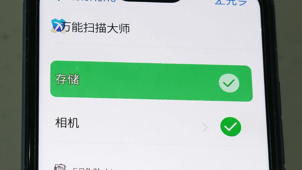 一部手机屏幕显示“万能扫描大师”的权限设置页面,页面上“存储”和“相机”权限被高亮显示为已开启状态,旁边有一个绿色的对勾图标,背景是手机系统设置界面风格,画质清晰,无多余元素