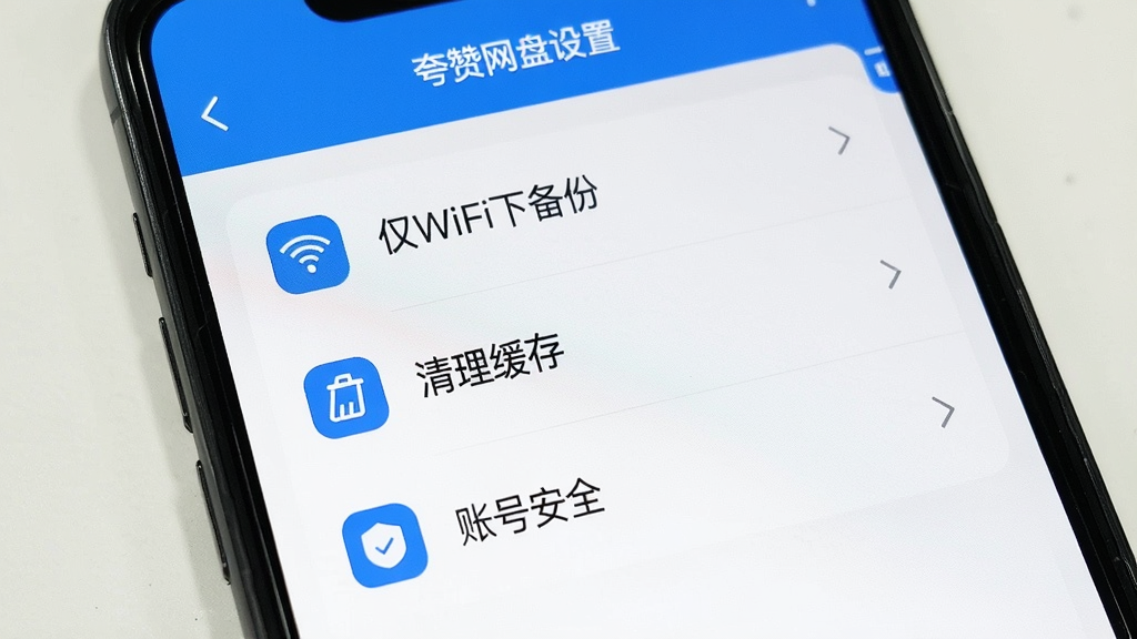 一张手机屏幕显示夸赞网盘设置页面的图片,页面中有“仅WiFi下备份”“清理缓存”“账号安全”等选项,界面简洁,蓝白配色,图标清晰,画质干净
