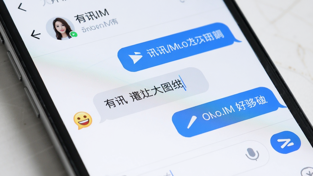 一张有讯IM软件界面特写生图,主体是手机屏幕展示有讯IM的聊天对话窗口,布局上方显示联系人名称,中间是气泡对话内容,下方是输入框和发送按钮,排版清晰,风格简洁明亮,细节包括蓝色发送气泡、灰色接收气泡、表情图标,画质干净无多余元素。