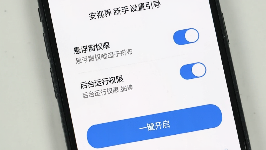 安视界新手设置引导界面,手机屏幕显示权限开启引导页面,包含“悬浮窗权限”“后台运行权限”两个开关选项,每个选项下方有简短说明文字,底部有“一键开启”蓝色按钮,背景为白色,风格简洁明了,画质清晰