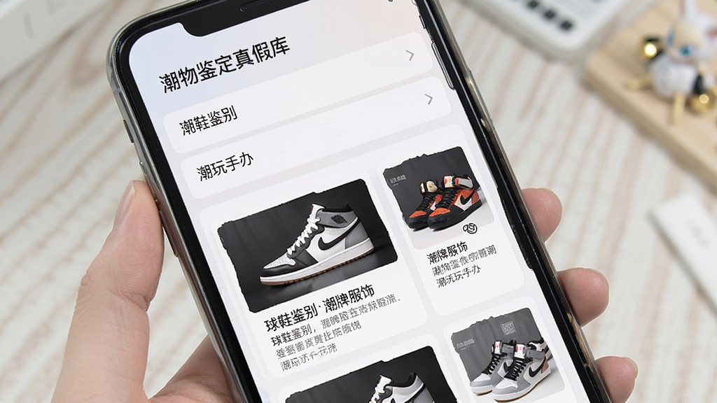 一张展示“潮物鉴定真假”软件知识库页面的图片,手机屏幕上显示分类列表,包含“球鞋鉴别”“潮牌服饰”“潮玩手办”等条目,点击进入后展示图文并茂的鉴别要点说明,界面排版整齐,采用卡片式设计,色调柔和,画质清晰干净,无多余装饰元素