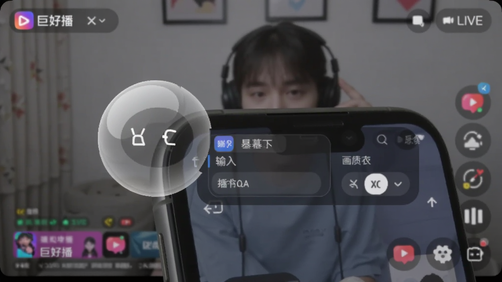 手机屏幕边缘悬浮着一个半透明的圆形控制球,展开后显示弹幕输入框和画质切换按钮,背景是直播画面,界面清爽,图标线条简洁,带有