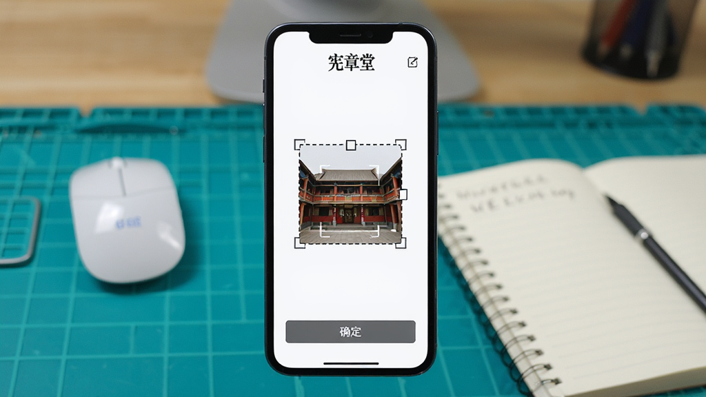 主体:手机屏幕显示宪章堂的导入图片页面,有裁剪框。布局:手机居中,背景为工作台,有鼠标和笔记本。排版:屏幕上有“宪章堂”的标识,裁剪框为虚线。风格:实用教程风格。细节:裁剪框可调整大小,界面有“确定”按钮。画质:清晰,无多余元素。