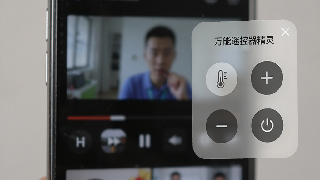 展示手机屏幕边缘有一个半透明的悬浮窗,悬浮窗上显示着“万能遥控器精灵”的迷你遥控器面板,有温度加减和电源按钮,背景是模糊的视频播放界面,风格写实,画质清晰。