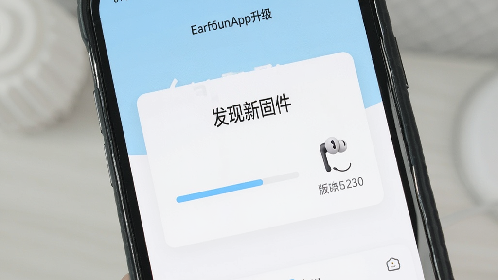 一张展示EarFun丽耳App固件升级功能的图片,手机屏幕上显示着“发现新固件”的提示框,下方有一个进度条正在缓慢前进,旁边配有一个耳机的图标和版本号信息。界面风格简洁,以白色和浅蓝色为主,画质干净,无多余元素。