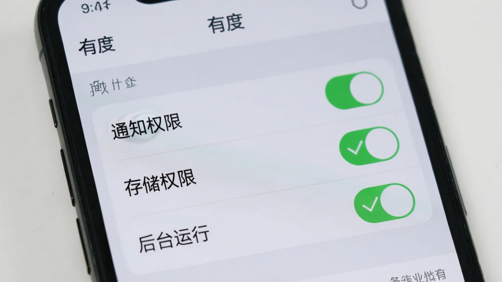 手机屏幕显示「有度」的设置页面,有“通知权限”、“存储权限”、“后台运行”等选项开关,旁边有绿色的勾选标记,背景是浅灰色,风格干净整洁,画质清晰