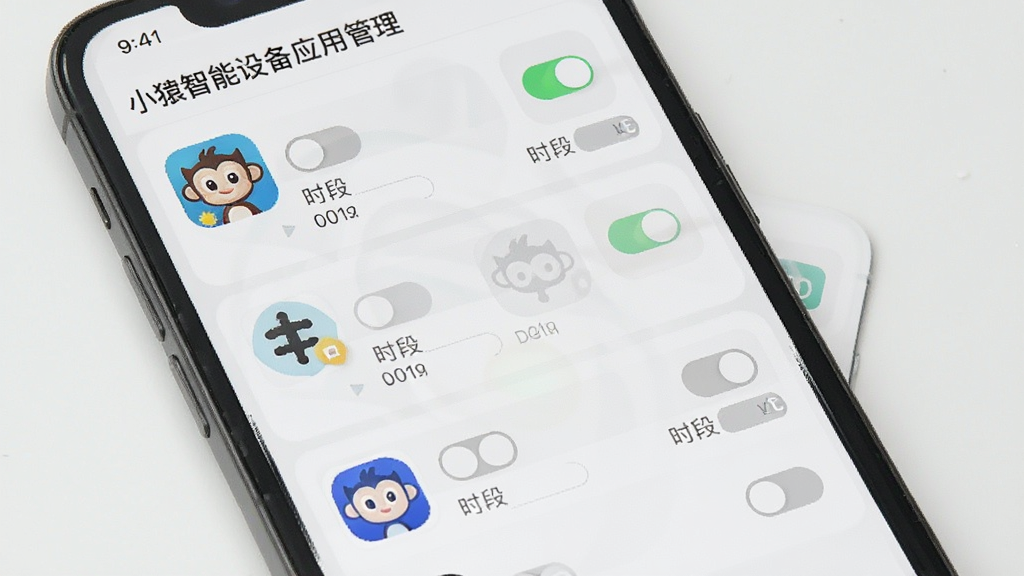 手机屏幕展示小猿智能设备的应用管理界面,画面中有多个应用图标排列整齐,每个图标旁边有开关按钮和时段设置选项,部分应用显示为禁用状态,整体布局清晰,风格简洁现代,画质干净无杂乱元素。