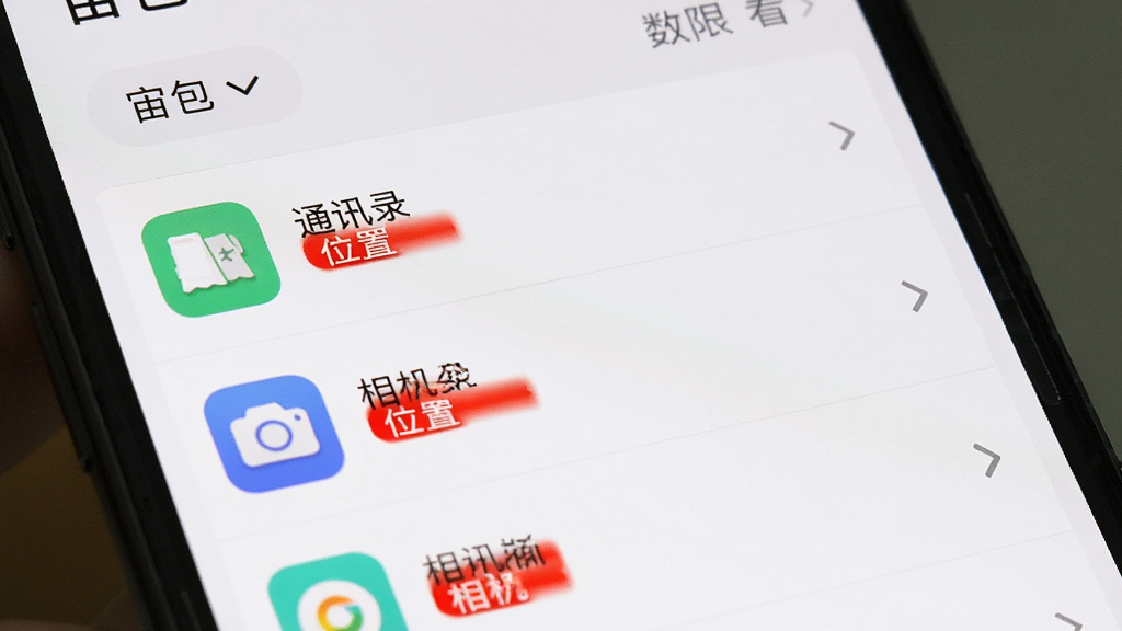 手机界面显示“宙包”权限查看页面,列表展示多个应用图标及其对应的权限标签,如“通讯录”“位置”“相机”等,部分权限用红色标记提醒,整体布局为上下结构,顶部有筛选按钮,风格简洁直观,画质干净无多余元素