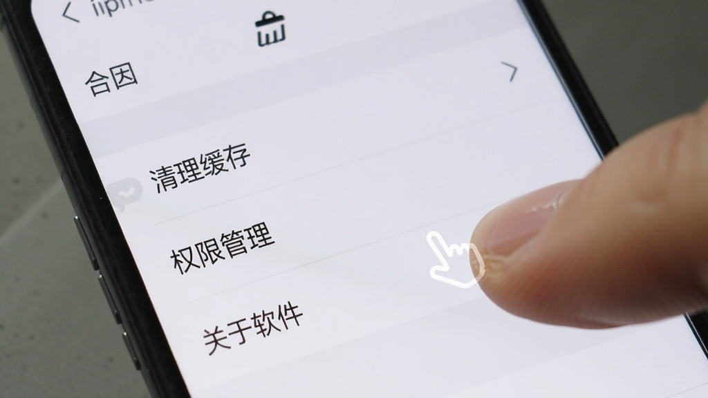手机屏幕上显示“合因”的设置菜单,菜单项包括“清理缓存”、“权限管理”、“关于软件”,界面风格简洁,有手指点击的示意,画质干净