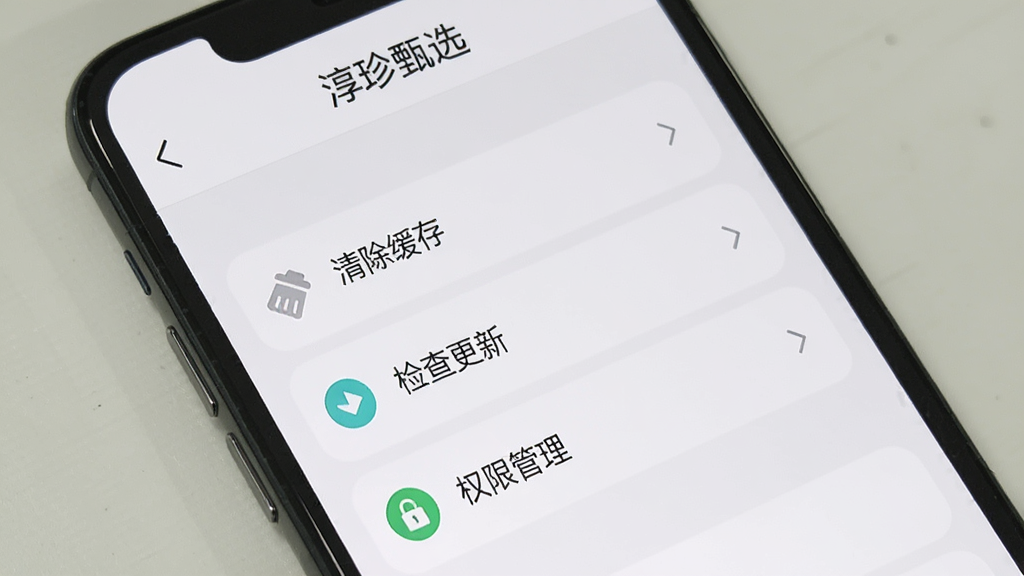 手机屏幕展示“淳珍甄选”的应用设置页面,页面上有“清除缓存”“检查更新”“权限管理”等选项,界面简洁,主色调为白色和浅灰色,图标清晰,画质干净无多余元素