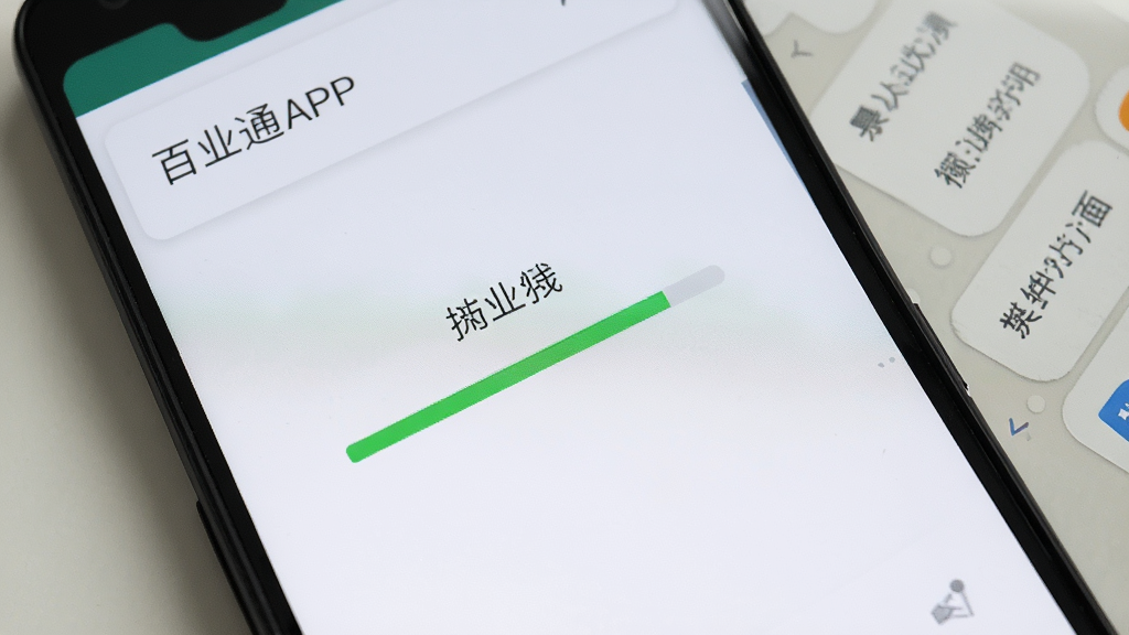 一部安卓手机屏幕显示“百业通”APP正在安装的界面,屏幕中央有安装进度条,背景为手机桌面,风格写实,画质清晰干净,无多余元素