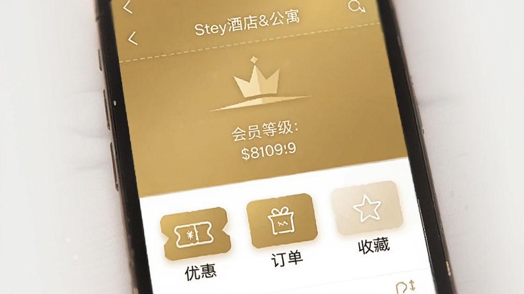 一个手机界面,展示“Stey酒店&公寓”的会员中心页面,页面中央显示会员等级和积分,下方有优惠券、订单、收藏等图标,配色以金色和白色为主,风格高端简洁,画质细腻