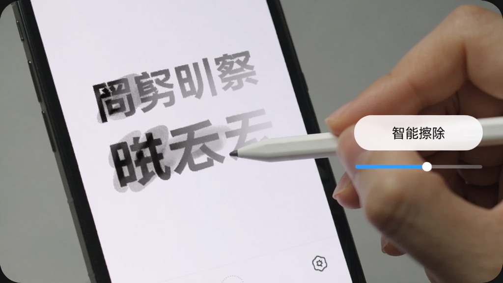 手机界面截图展示,画面中一只手用触控笔在手机上涂抹图片中的文字,被涂抹的区域逐渐消失并融入周围背景,画面右侧弹出“智能擦除”按钮和进度条,界面风格清爽,画质清晰干净