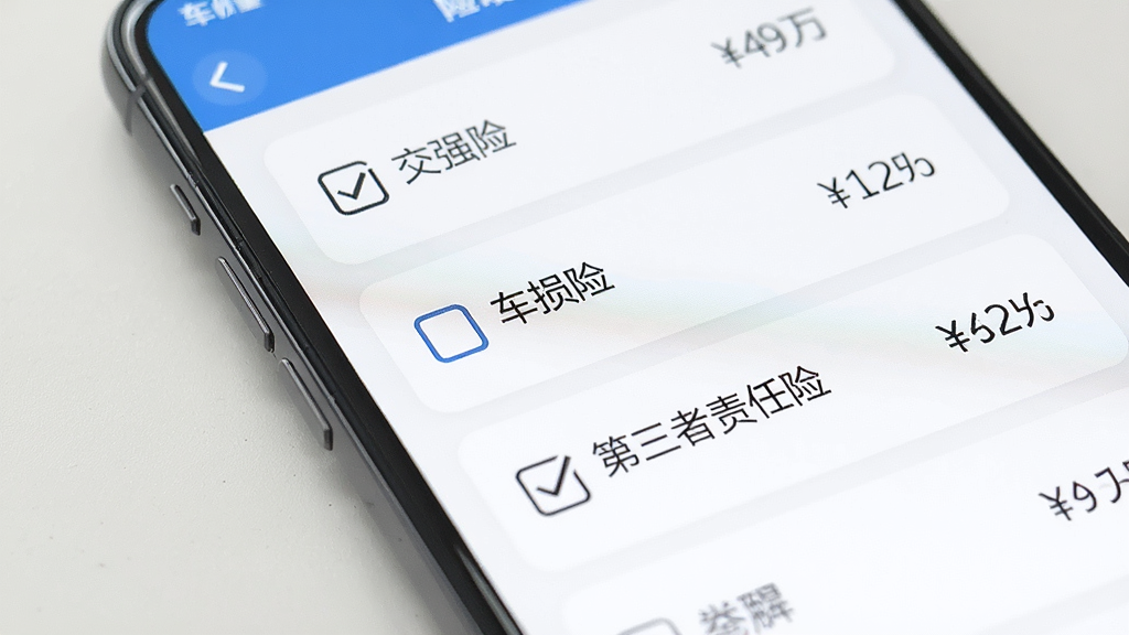 一张手机屏幕的特写图,展示车险价格计算应用的险种勾选界面,画面上有交强险、车损险、第三者责任险等选项,每个选项旁边有勾选框和对应的价格数字,界面以白色卡片式布局呈现,文字清晰,风格干净整洁,画质细腻无多余元素
